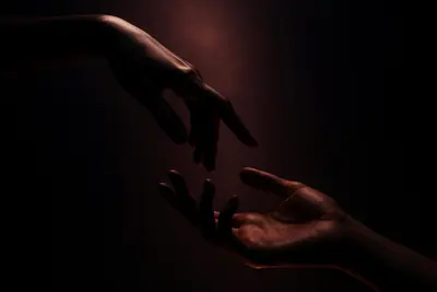 Two hands reaching toward each other